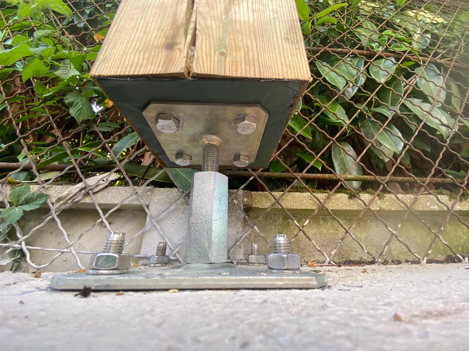 Détail du pied de poteau bois sur platine métallique réglable d'un carport à Crépy-en-Valois dans l'Oise