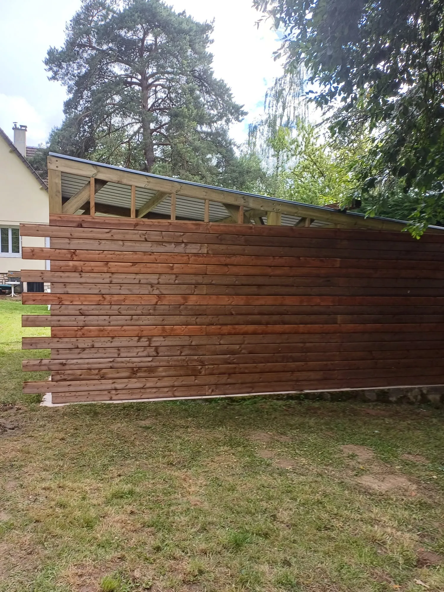 Bardage bois et bord de toiture bac acier d'un carport en bois, réalisé dans l'Aisne
