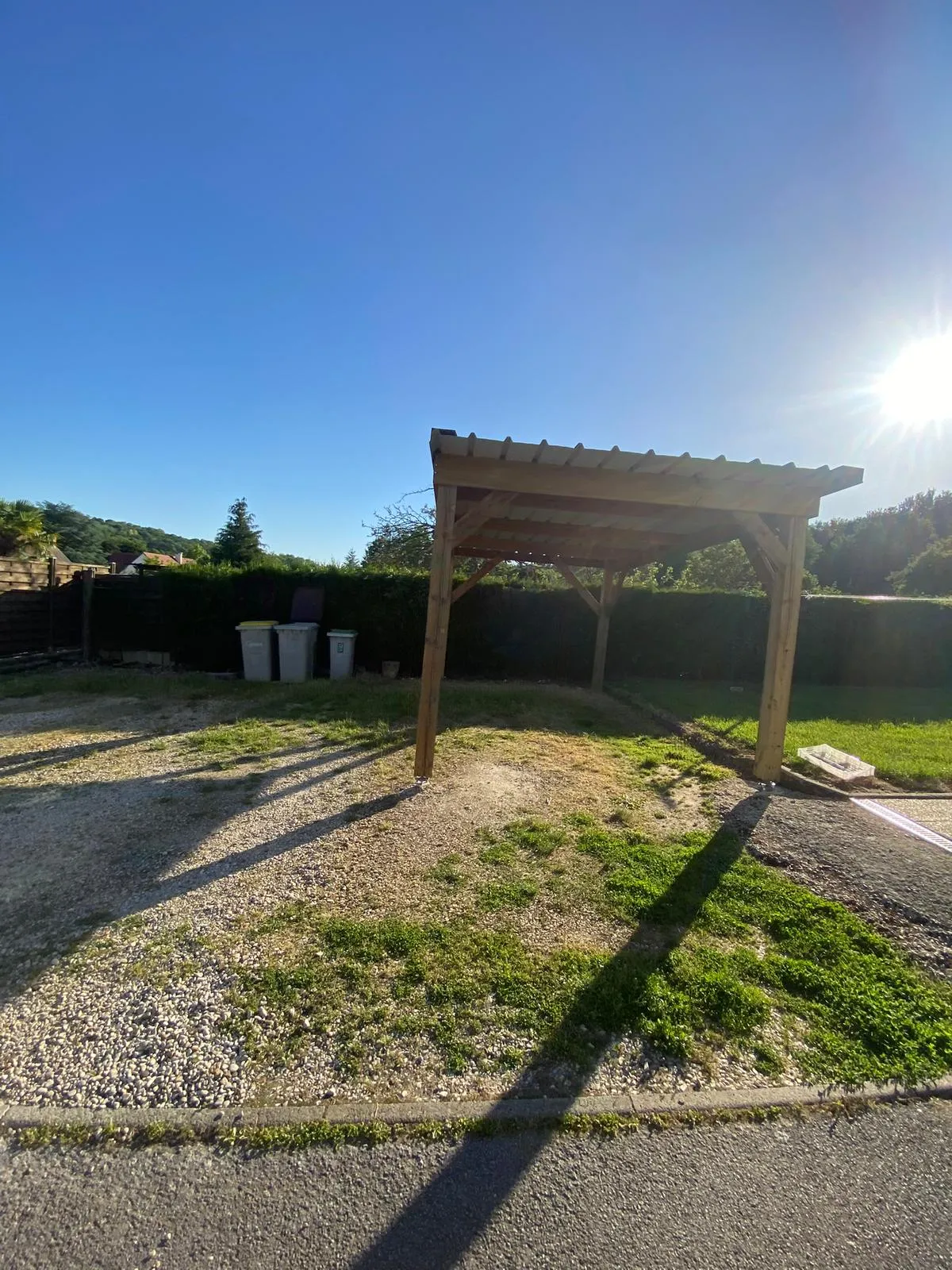 Carport bois mono-pente vu de profil avec sa toiture bac acier, dans l'Aisne