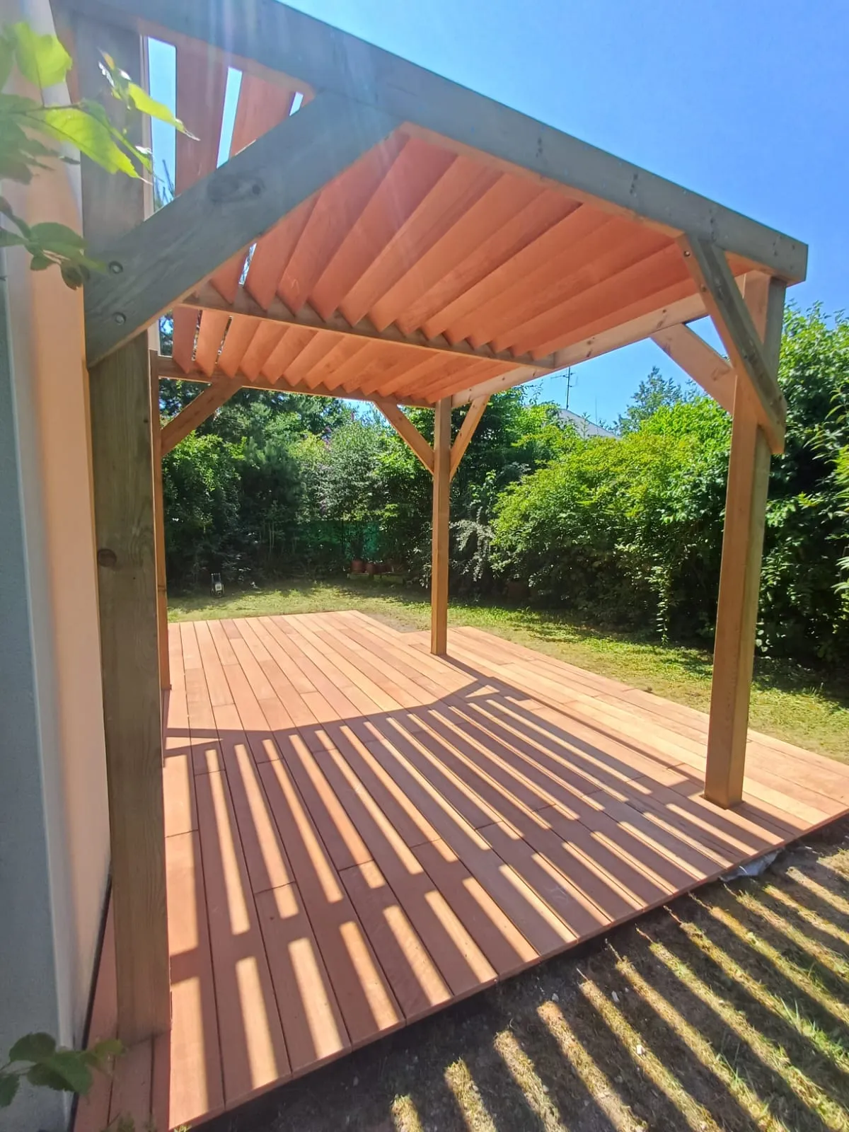 Pergola bois avec toiture à chevrons sur terrasse, réalisée par La Planète Bois près de Soissons