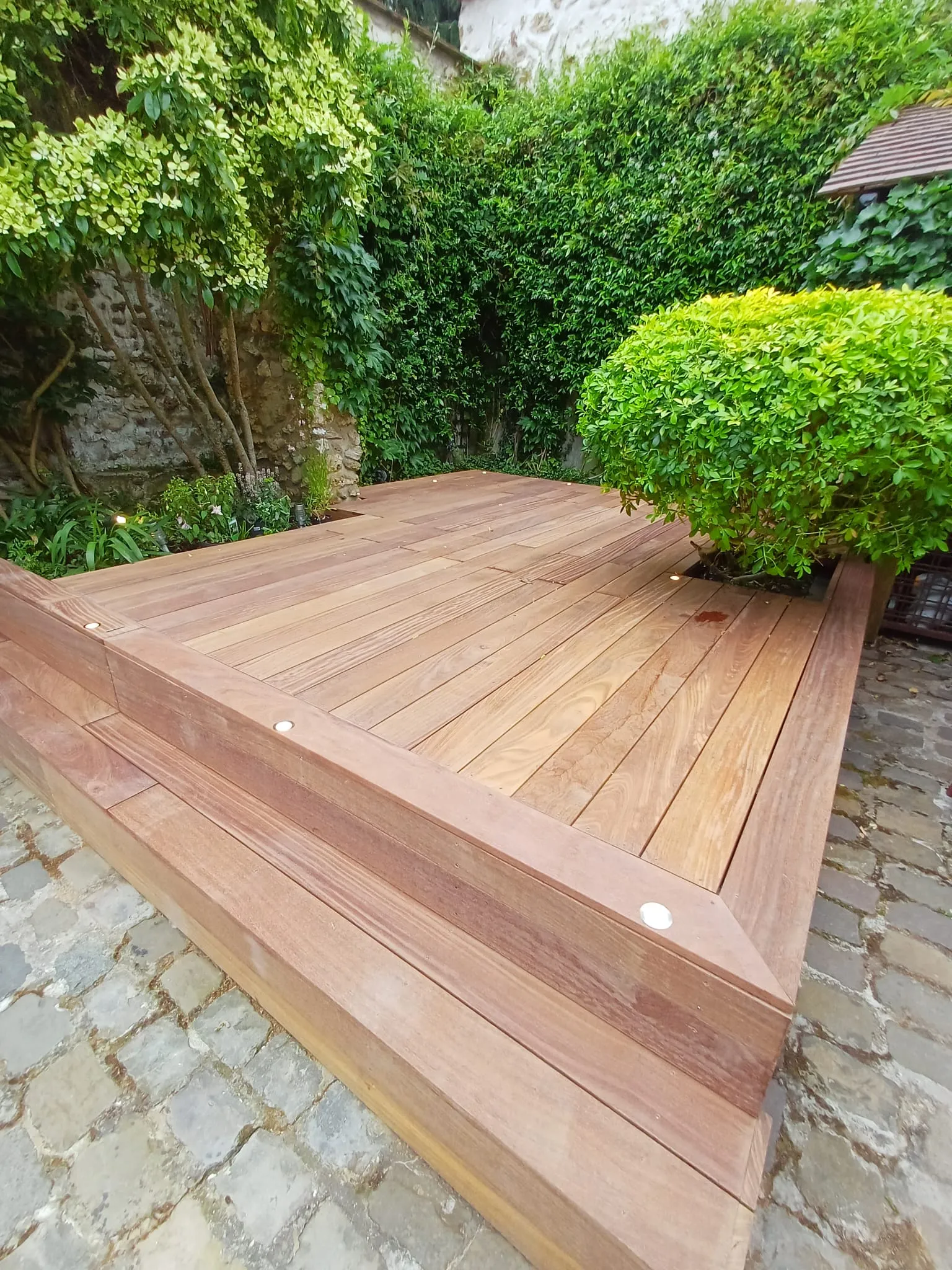 Terrasse bois exotique en cumaru avec marche d'angle et spots LED encastrés, réalisée à Chambourcy