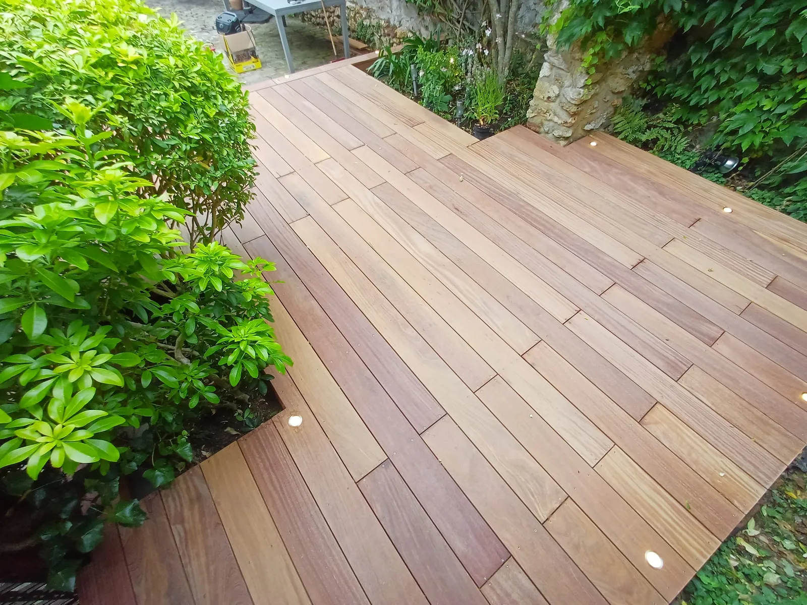 Lames de terrasse bois exotique cumaru bordées de végétation avec spots encastrés, à Chambourcy