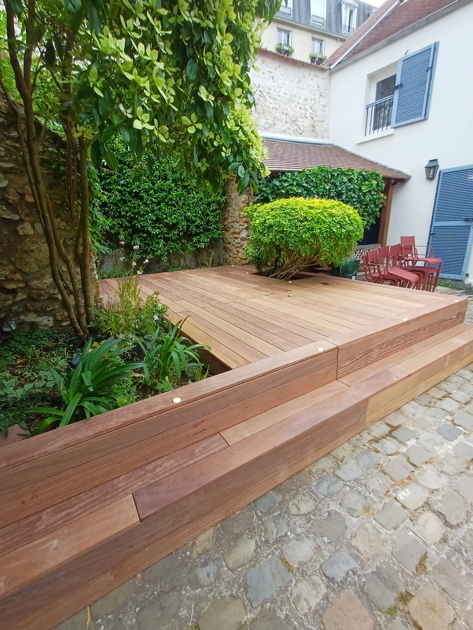 Vue large d'une terrasse bois exotique cumaru avec emmarchement devant la maison, à Chambourcy